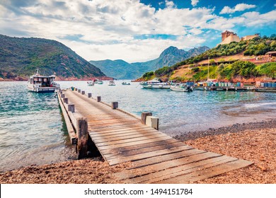 Old Wooden Pier In Port De Girolata - Place, Where You Can't Get By Car. Sunny Summer Scene Of Corsica Island, France, Europe. Beautiful Mediterranean Seascape. Traveling Concept Background.
