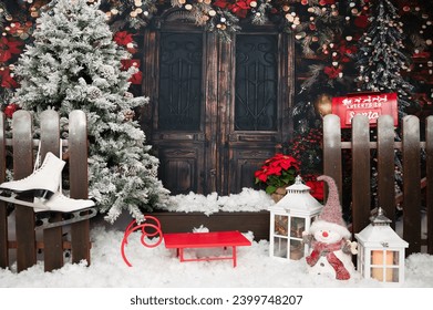 An old wooden pivot door is decorated brightly with christmas and new years decoration the place seen from the exterior typical christmas wreath and ornamental decoration, snowman and christmas tree - Powered by Shutterstock