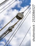 Old wooden pully on a ship with ropework against a blue summer sky