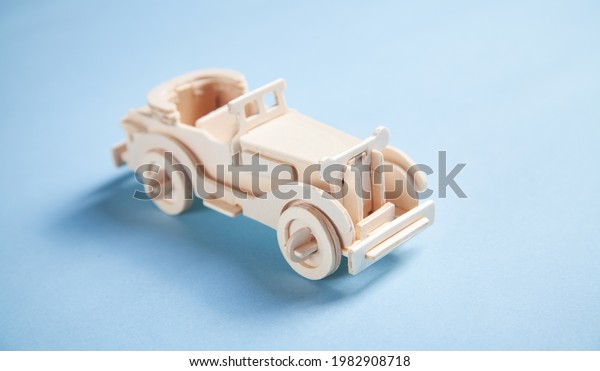 Old wooden
retro toy car on the blue
background.