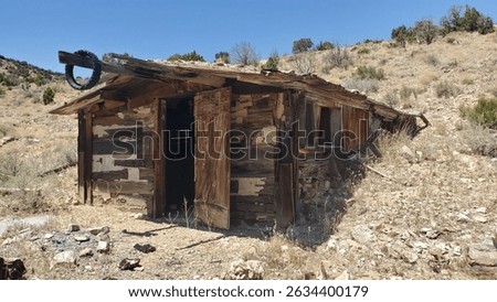 old wooden shack house built into hillside 