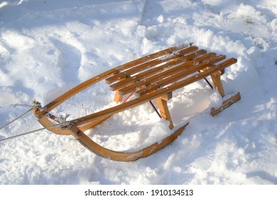 Old wooden sledge in the fresh snow. Winter sports, vacations and games concept concept. Sled with rope