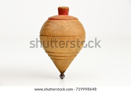 Old wooden spinning top on against a white background