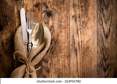 The old wooden table cutlery on the burlap.
