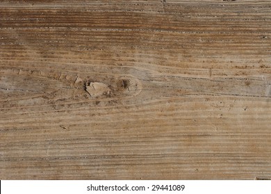 An old wooden texture with grains of sand in the cracks found at the sea shore.