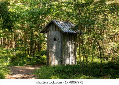 Old wooden toilet in the woods. Outhouse in the wood.