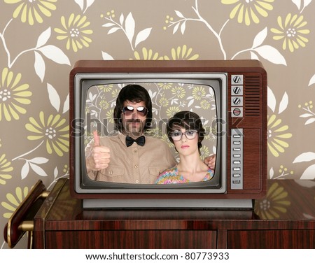 old wooden tv with nerd silly couple retro in screen on wallpaper background [Photo Illustration]