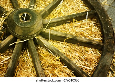old wooden wagon wheel lies in the manger