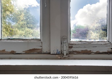 Old wooden window frames with rotting wood and cracked peeling paint, house needs renovation and new frames closeup - Shutterstock ID 2004595616