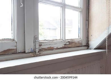 Old wooden window frames with rotting wood and cracked peeling paint, house needs renovation and new frames closeup - Shutterstock ID 2004599144