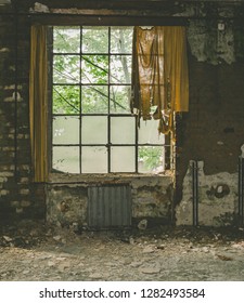 An Old Wooden Windows With Tattered Curtain