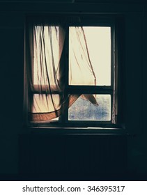 An Old Wooden Windows With Tattered Curtain