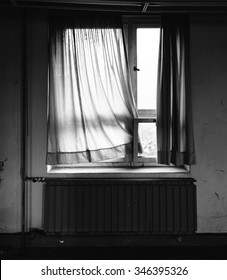 An Old Wooden Windows With Tattered Curtain