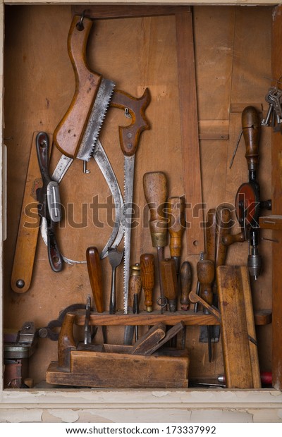 Old woodworking\
tools in carpentry shelf.