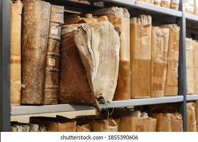 Old worn 17th century books on a shelf in the library's archives
