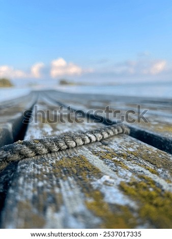 Old and worn down but trusty rope waiting for more active use again at pier.