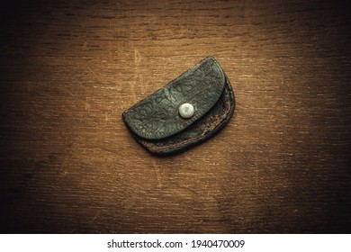 An Old Worn Leather Wallet On A Wooden Table