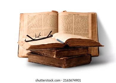 Old worn shabby jewish books in leather binding and open blurred Torah in the background. Closeup. Selective focus