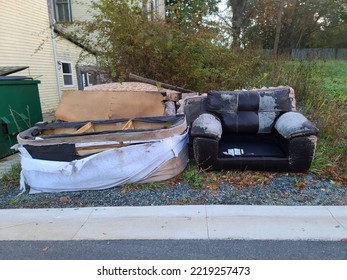 Old worn and used furniture chucked out alongside of a road and left there.  - Shutterstock ID 2219257473