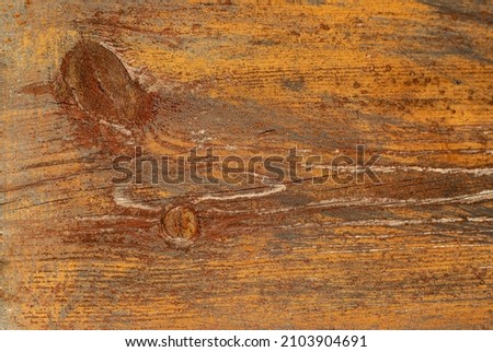 Old and worn wood texture in ocher tones with knots and cracks ideal for backgrounds and various designs