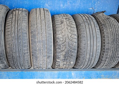 Old Worn-out Tires Are Stacked On A Metal Rack