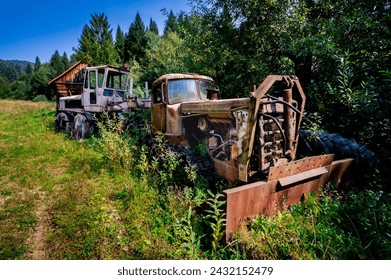 Old, wrecked machinery, abandoned snow blower and machine in the bushes. Rusty, unused, heavy vehicles in a mountain forest. Bieszczady, sunny, summer day. - Powered by Shutterstock