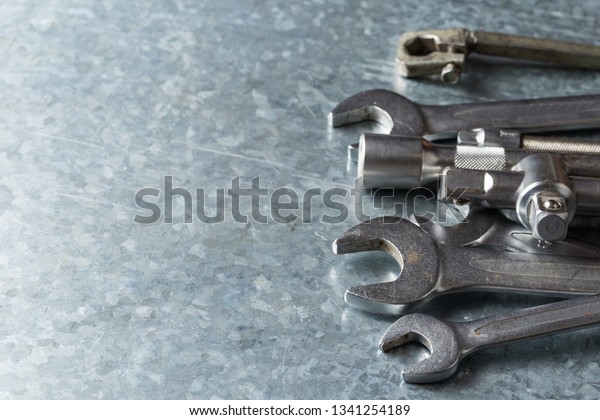 old wrench and tools and Engine spare parts on\
rusty background