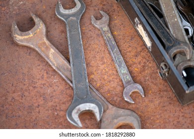 Old wrenches on a rusty sheet of metal, close-up, selective focus.