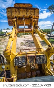 Old Yellow Broken Bulldozer. Construction Machinery With Trees In The Background