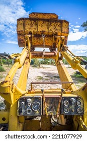 Old Yellow Broken Bulldozer. Construction Machinery With Trees In The Background