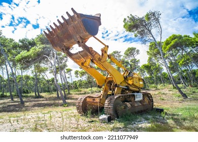 Old Yellow Broken Bulldozer. Construction Machinery With Trees In The Background