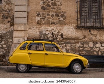 An old yellow car parked in the background of a medieval wall - Powered by Shutterstock