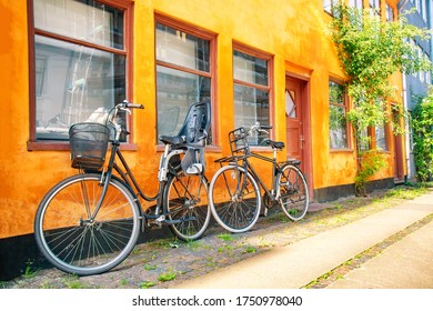 Old yellow house of Nyboder district with bicycles. Old Medieval district in Copenhagen, Denmark. Summer sunny day.