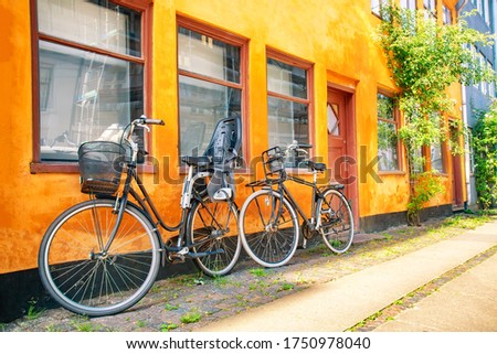 Old yellow house of Nyboder district with bicycles. Old Medieval district in Copenhagen, Denmark. Summer sunny day.