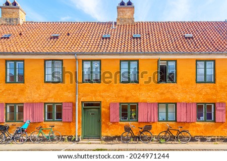 Old yellow house of Nyboder district with bikes. Old Medieval district in Copenhagen, Denmark. Picturesque of Copenhagen