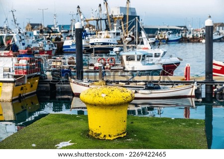 Old yellow moorage and fishing ships in the small trading port of Howth, fishing village near Dublin, Ireland