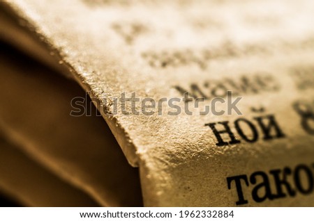 Old, yellow paper page surface with cyrillic letter print. Shallow depth of field, macro image for abstract background.