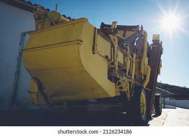 Old yellow threshing machine under the sun