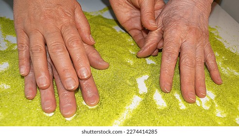 old and young female hands on green kinetic sand, sand therapy for rehabilitation after a stroke. - Powered by Shutterstock