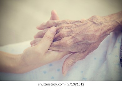 Old and young holding hands on light background, vintage tone. - Powered by Shutterstock