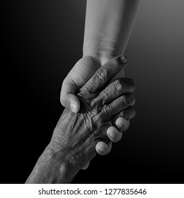 Old And Young Person Holding Hands. Elderly Care And Respect, .black And White Photography. Space For Text.family, Generation, Support And People Concept -senior Man And Child Holding Hand