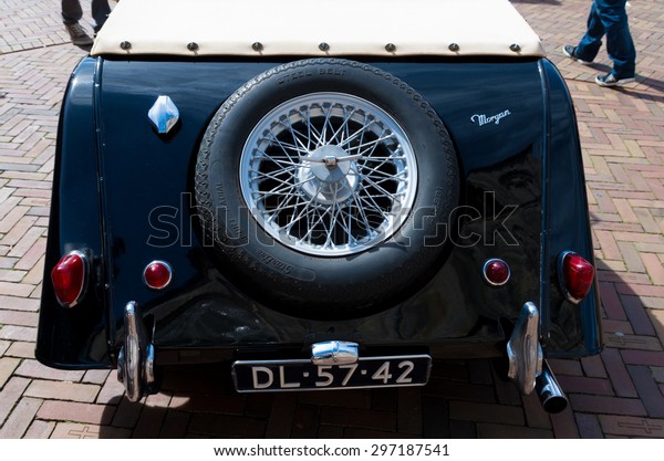 OLDENZAAL, NETHERLANDS - APRIL 27, 2015: Black\
oldtimer car with spare wheel during the 14th orange tour. This\
annual tour takes places during the king\'s birthday celebrations, a\
national holiday.