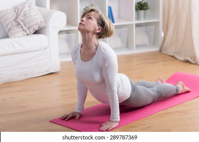 Older Active Woman Exercising Yoga In The Morning