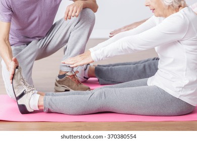 Older Active Woman Stretching Her Legs On Gym