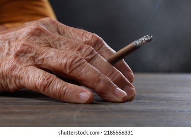 Older, Adult Man Holds Cigarette In Her Hand On Table. Concepts Of Women's Health, Bad Habits, Addiction. Shallow Depth Of Field