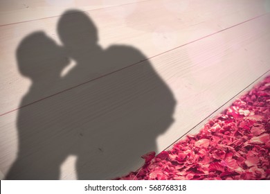 Older Affectionate Couple Holding Red Heart Shape Against Autumn Leaves Against White Wood