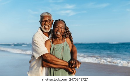 An older African American couple embrace warmly during a joyful walk along a sandy beach. Their happiness radiates in the sunlight. - Powered by Shutterstock