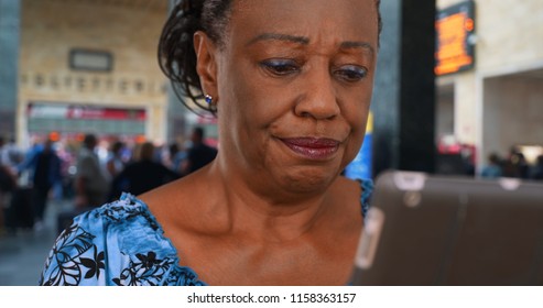 Older African American Woman Waiting At The Airport Uses Digital Tablet