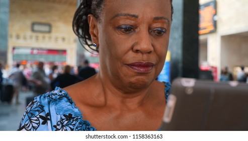 Older African American Woman Waiting At The Airport Uses Digital Tablet