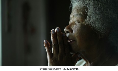 An older African woman praying to God closing eyes with HOPE and FAITH - Powered by Shutterstock